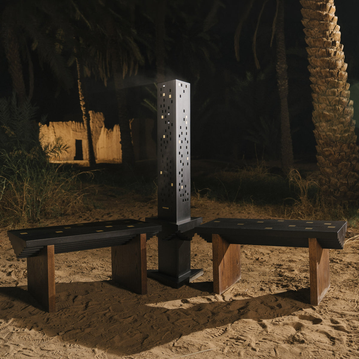 Sira Ladi, autel à encens noir entre deux bancs, installé de nuit dans l'oasis d'AlUla