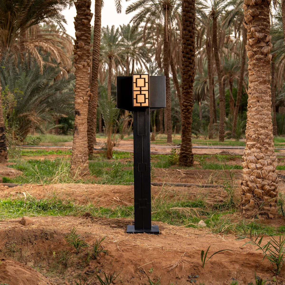 Tamaro Ja, sculpture lumineuse noire couronnée de papier de palme, dans une palmeraie d'AlUla