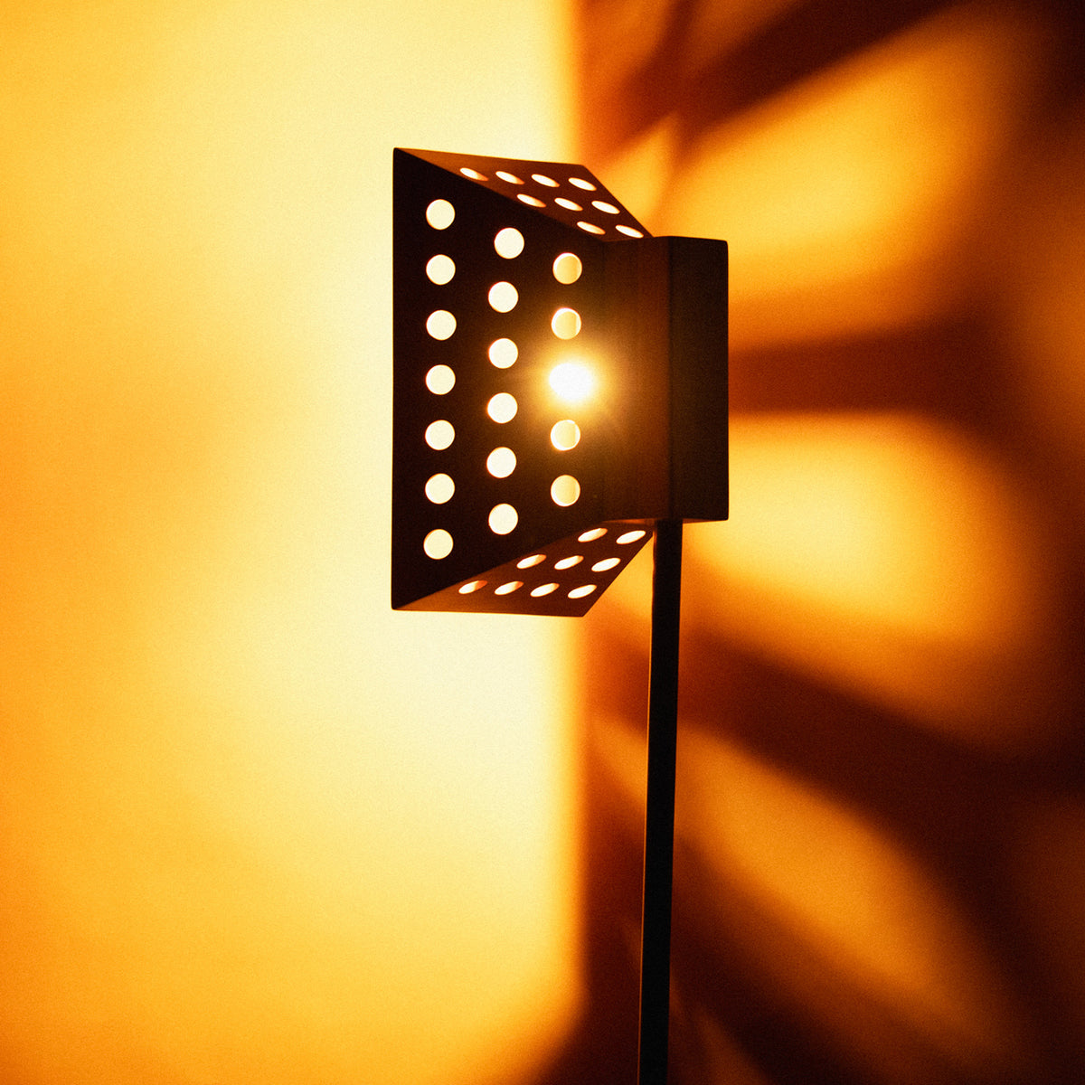 Ombres projetées sur le mur par le lampadaire Oko allumé