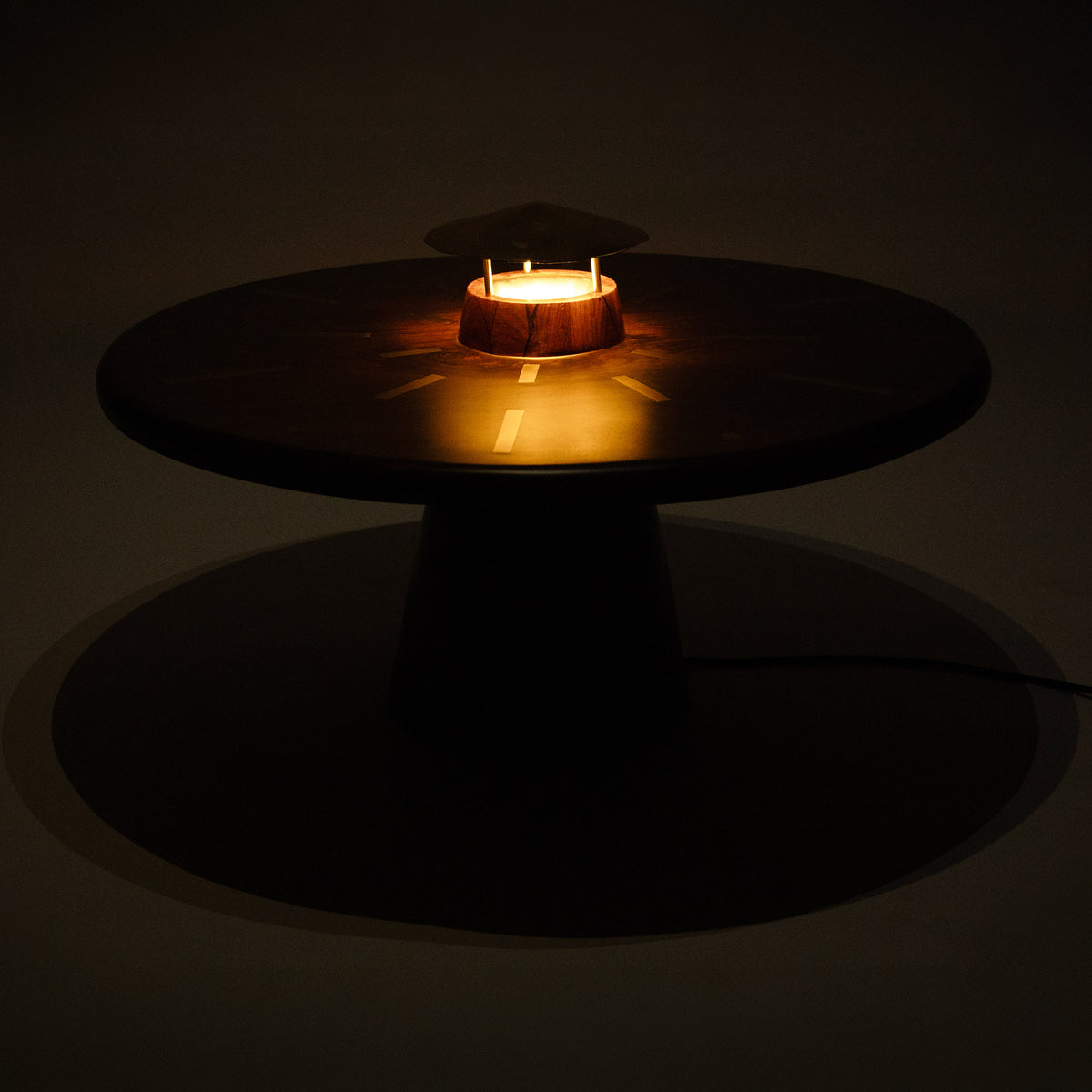 Table lumineuse Yelen allumée dans l'obscurité, lumière diffusée sous le chapeau central